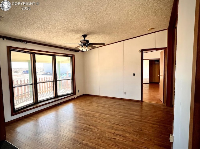 empty room with a ceiling fan, crown molding, a textured ceiling, and wood finished floors