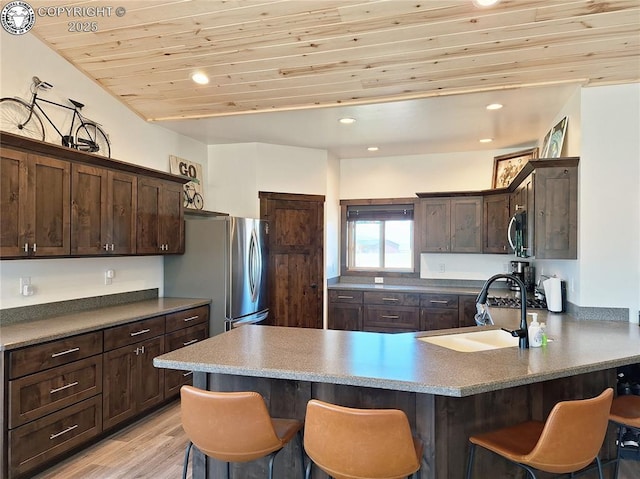 201 Fox Run, Silver Cliff, CO 81252 - kitchen featuring a kitchen bar, dark brown cabinetry, a peninsula, wood ceiling, and appliances with stainless steel finishes
