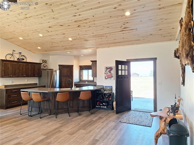 201 Fox Run, Silver Cliff, CO 81252 - kitchen with a kitchen breakfast bar, dark brown cabinetry, wood ceiling, a peninsula, and light wood-style floors