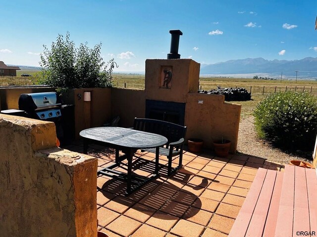 2 Inverness Ave, Westcliffe, CO 81252 - view of patio / terrace featuring a fireplace, a mountain view, a view of rural / pastoral area, and a grill