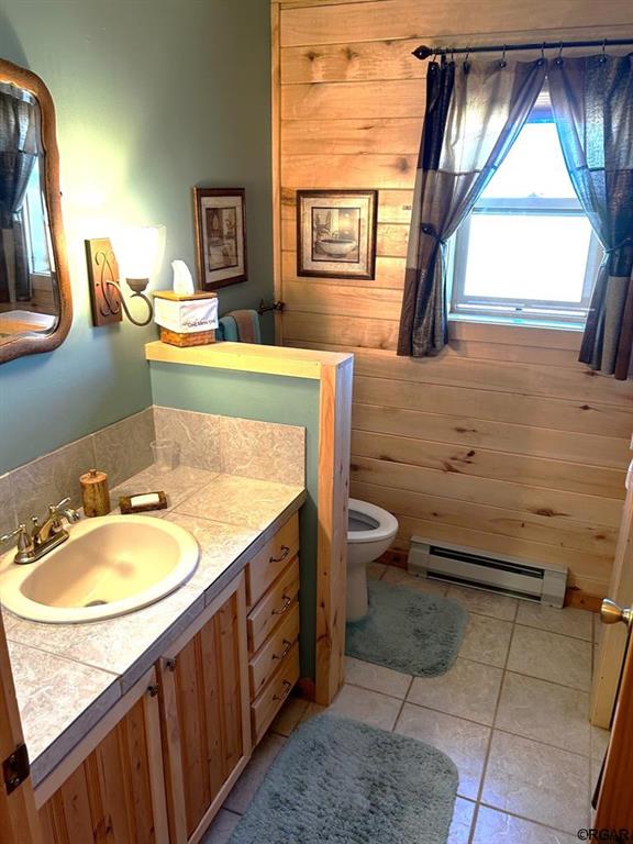 2 Inverness Ave, Westcliffe, CO 81252 - bathroom with baseboard heating, toilet, vanity, and tile patterned floors