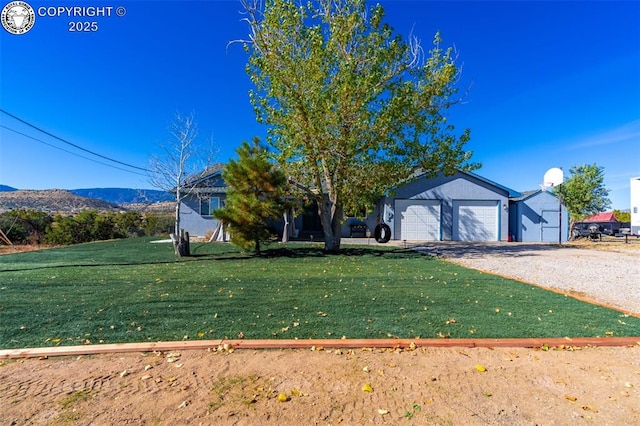 view of front of property with a mountain view, a garage, and a front lawn