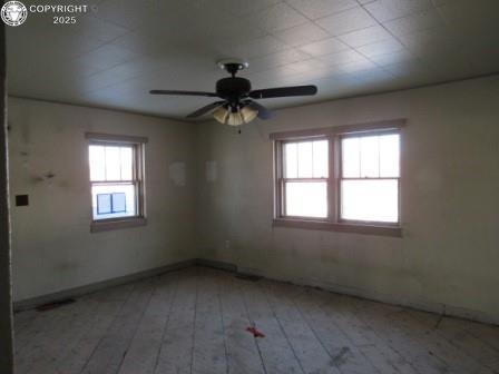 unfurnished room with ceiling fan, a wealth of natural light, and light hardwood / wood-style floors