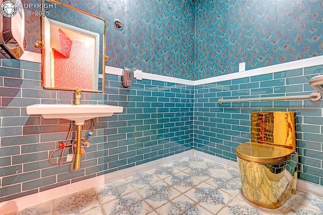 122 W Main St, Florence, CO 81226 - bathroom with wallpapered walls, wainscoting, tile walls, and a sink