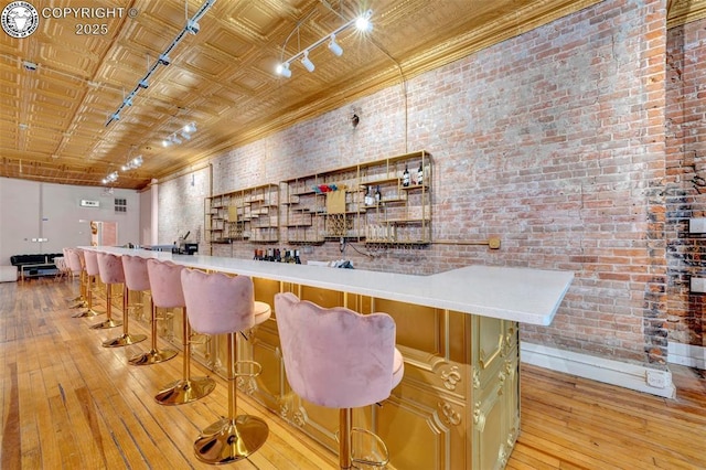 122 W Main St, Florence, CO 81226 - community bar area featuring track lighting, brick wall, light wood finished floors, and baseboards