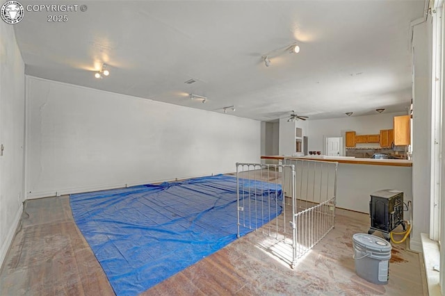 122 W Main St, Florence, CO 81226 - misc room featuring a wood stove, a ceiling fan, and baseboards