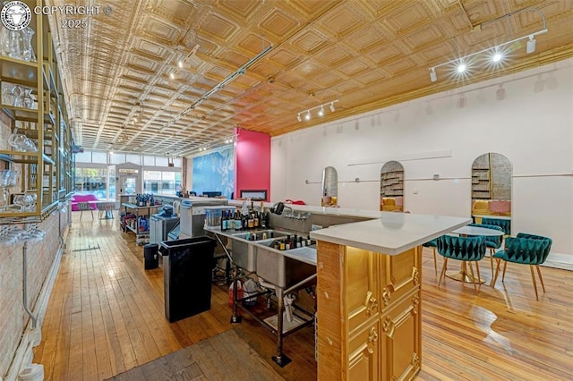 122 W Main St, Florence, CO 81226 - kitchen with light wood-type flooring, an ornate ceiling, light countertops, and a kitchen island