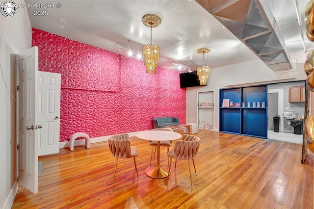 122 W Main St, Florence, CO 81226 - dining area with wallpapered walls, hardwood / wood-style floors, an accent wall, and baseboards