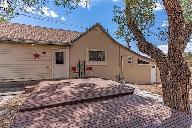 rear view of property featuring a wooden deck