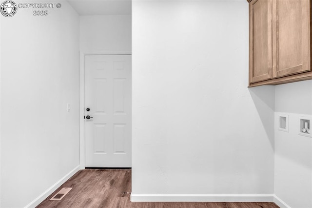 laundry area featuring washer hookup, wood-type flooring, and cabinets