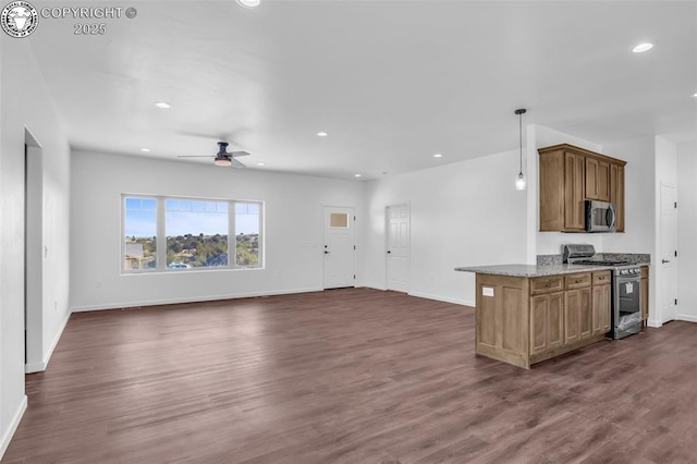 kitchen featuring dark wood-type flooring, appliances with stainless steel finishes, pendant lighting, ceiling fan, and light stone countertops