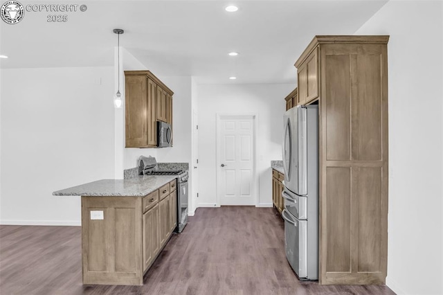 kitchen with light stone counters, hardwood / wood-style floors, decorative light fixtures, and stainless steel appliances