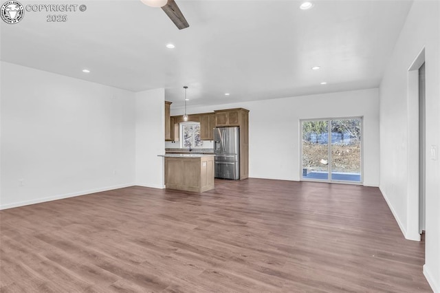 unfurnished living room featuring ceiling fan and dark hardwood / wood-style floors