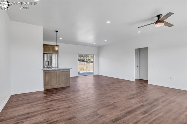 unfurnished living room featuring ceiling fan and dark hardwood / wood-style flooring