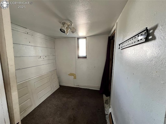 basement with a textured ceiling and baseboard heating