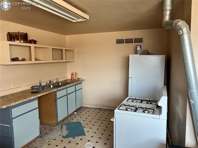 kitchen with sink, white appliances, and blue cabinetry