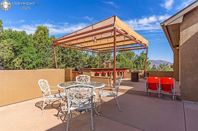 view of patio / terrace with a bar, a pergola, and a mountain view