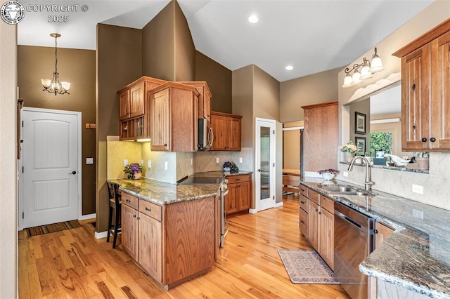 kitchen featuring appliances with stainless steel finishes, light hardwood / wood-style floors, sink, and decorative backsplash