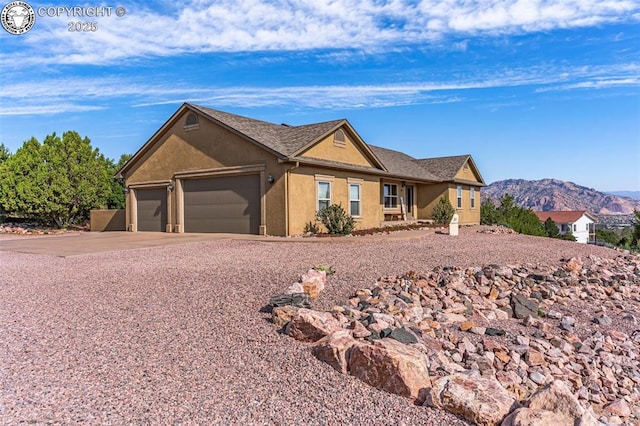 ranch-style home with a garage and a mountain view