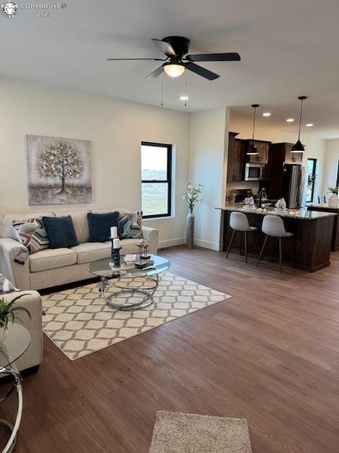 living room featuring ceiling fan and dark wood-type flooring