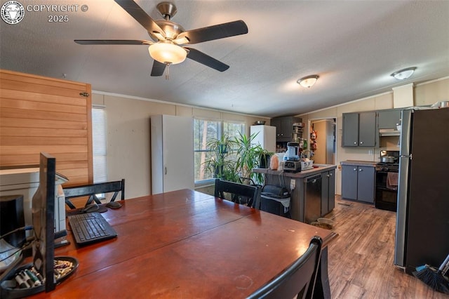 dining room with hardwood / wood-style flooring, lofted ceiling, a textured ceiling, and ceiling fan