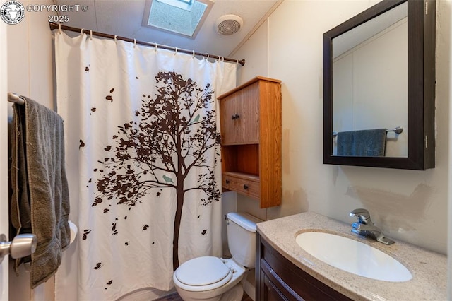 bathroom featuring vanity, a shower with curtain, a skylight, and toilet