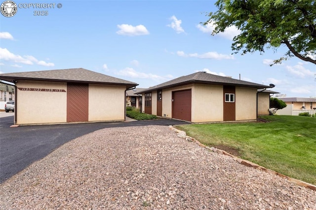 1125 Barr Ave, Canon City, CO 81212 - view of side of property featuring a yard, a garage, stucco siding, and driveway