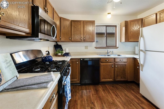 1125 Barr Ave, Canon City, CO 81212 - kitchen with black appliances, dark wood finished floors, brown cabinetry, and light countertops