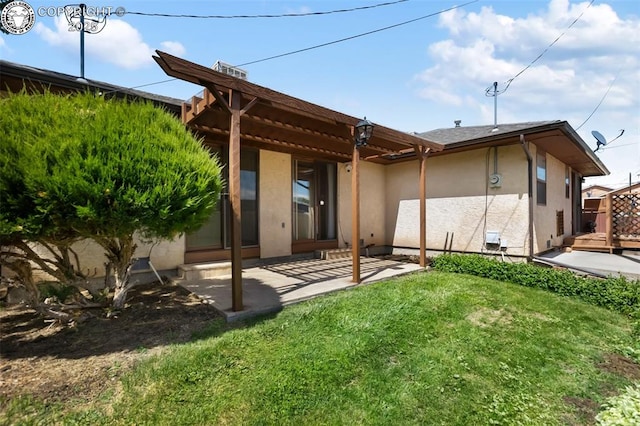 1125 Barr Ave, Canon City, CO 81212 - rear view of property featuring stucco siding, a lawn, and a patio