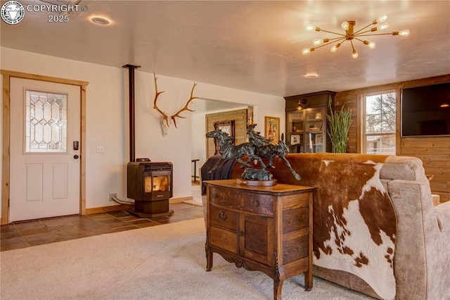 living area featuring carpet, a wood stove, baseboards, and heating unit