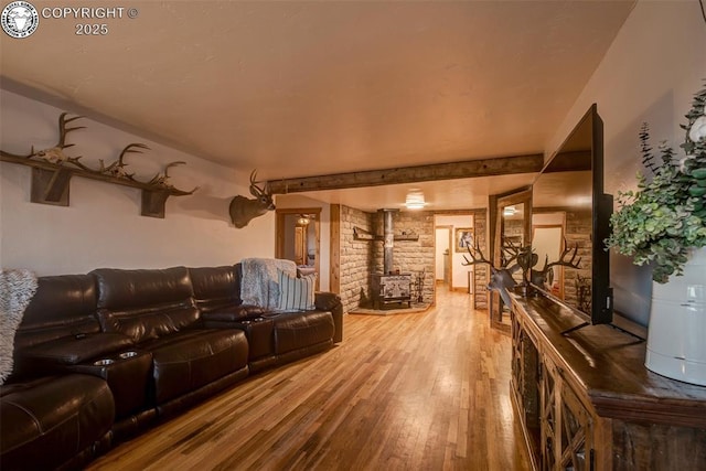 home theater room with a wood stove and hardwood / wood-style floors