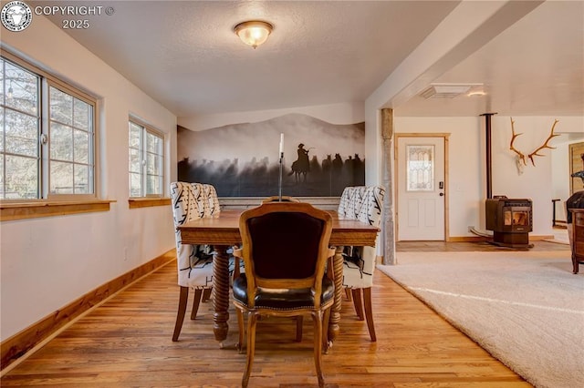 dining room with a textured ceiling, baseboards, and wood finished floors