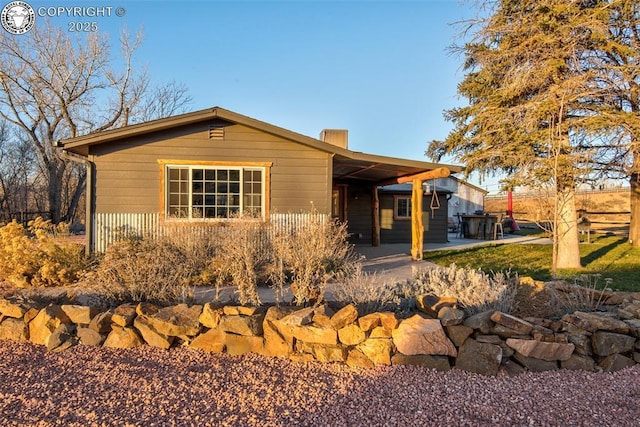 view of front of property with fence and a patio