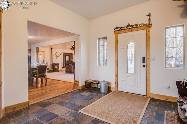 entryway with baseboards and stone tile floors