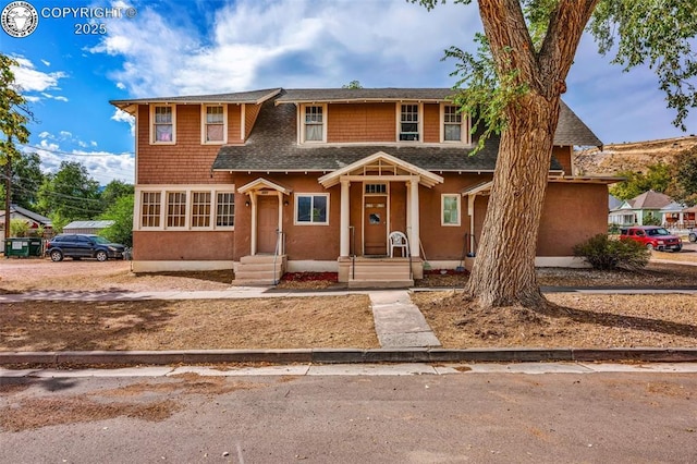 view of front of house featuring stucco siding and roof with shingles