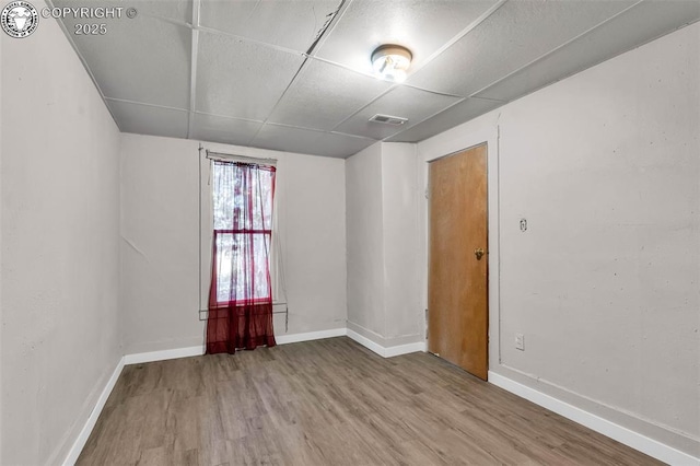 empty room with visible vents, baseboards, and wood finished floors