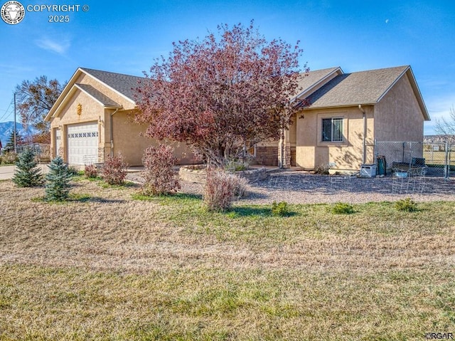 view of front of home with a garage and a front lawn