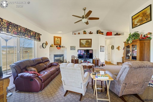 living room featuring a tiled fireplace, lofted ceiling, and ceiling fan