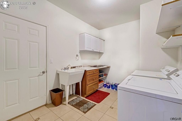 clothes washing area featuring cabinets, separate washer and dryer, and light tile patterned floors