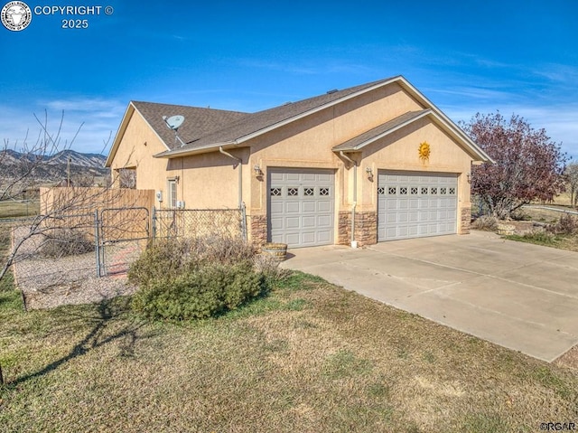 view of front of house with a garage, a mountain view, and a front lawn