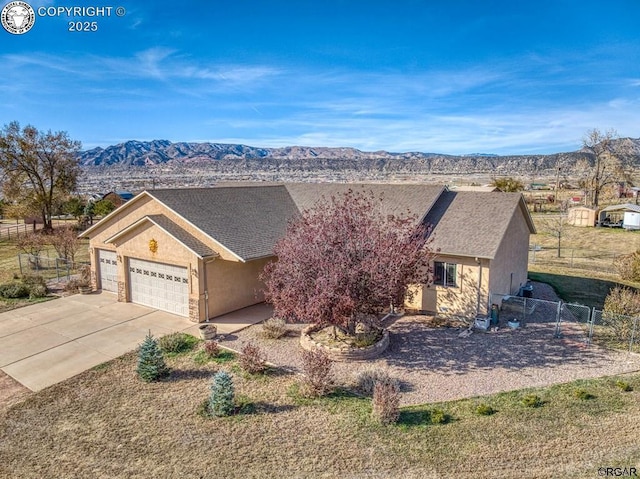 ranch-style home with a garage and a mountain view