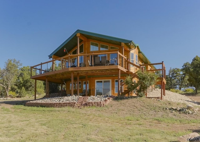 rear view of house featuring a deck and a lawn