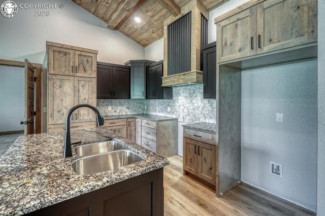 79 Terrazo Abajo, Westcliffe, CO 81252 - kitchen with wood ceiling, dark stone countertops, tasteful backsplash, light wood-type flooring, and wall chimney exhaust hood