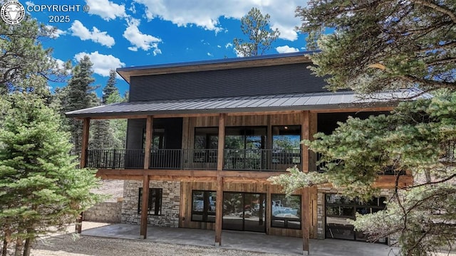 79 Terrazo Abajo, Westcliffe, CO 81252 - view of front of property with a patio, stone siding, a metal roof, and a balcony