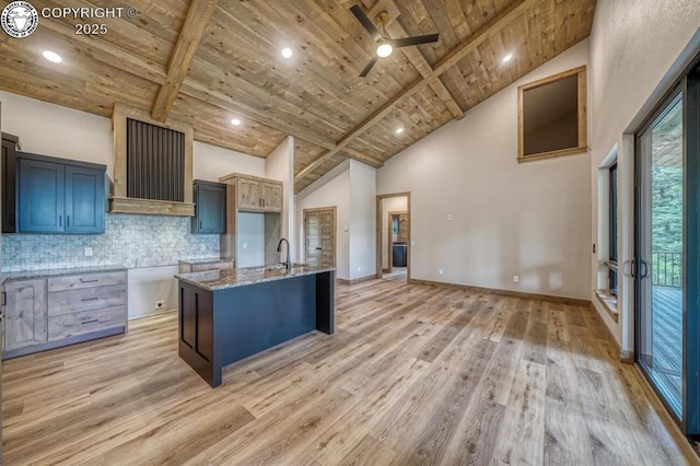 79 Terrazo Abajo, Westcliffe, CO 81252 - kitchen featuring a wood ceiling with exposed beams, exhaust hood, light wood-style floors, tasteful backsplash, and light stone counters