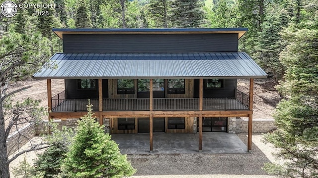 79 Terrazo Abajo, Westcliffe, CO 81252 - view of front of home featuring a patio area, a metal roof, and a wooded view