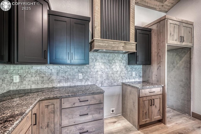 79 Terrazo Abajo, Westcliffe, CO 81252 - kitchen with dark stone counters, tasteful backsplash, light wood finished floors, premium range hood, and a textured wall