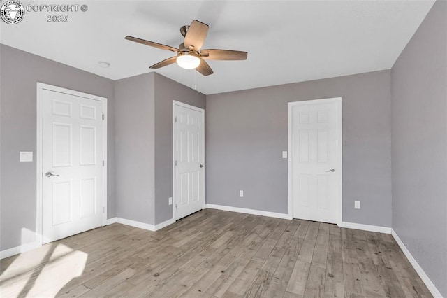 unfurnished bedroom with light wood-style floors, baseboards, and a ceiling fan