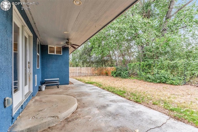 view of patio with ceiling fan and fence