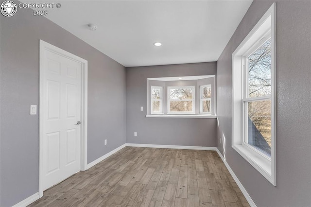 spare room with light wood finished floors and baseboards